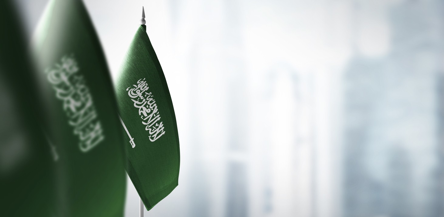 Small flags of Saudi Arabia on a blurry background of the city